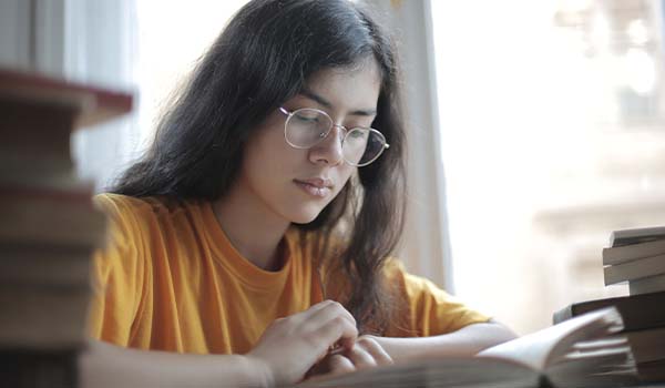 Etudiante avec des lunettes en train de lire