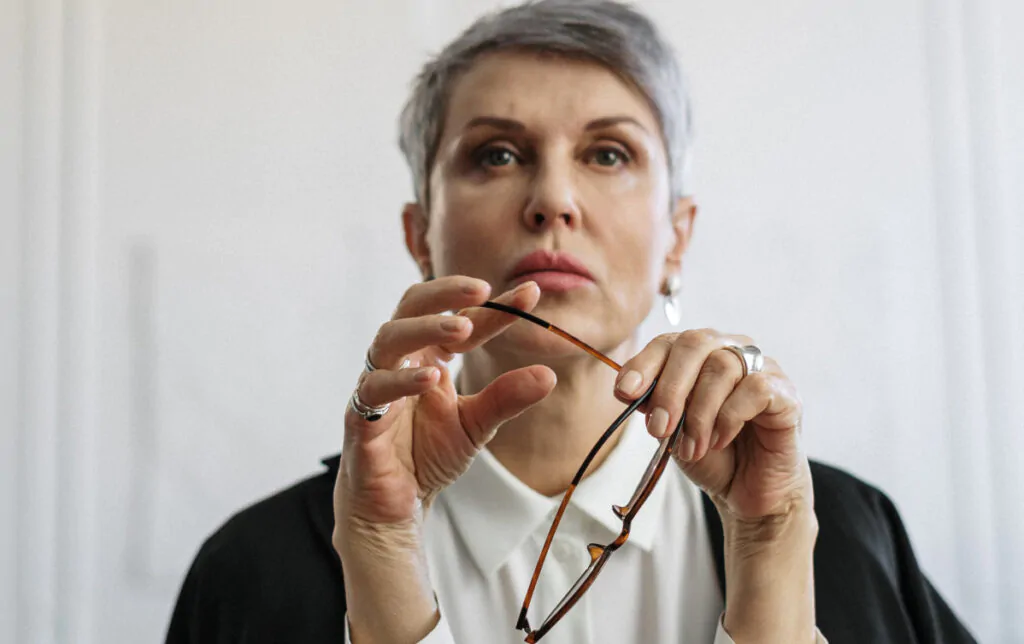 Femme avec lunettes se demandant si elle a besoin de verres progressifs ou non.