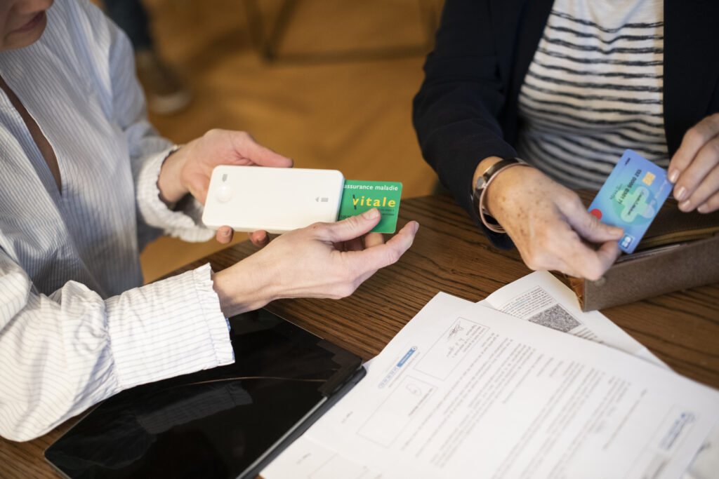 Opticienne introduisant la carte vitale d'une client dans son lecteur