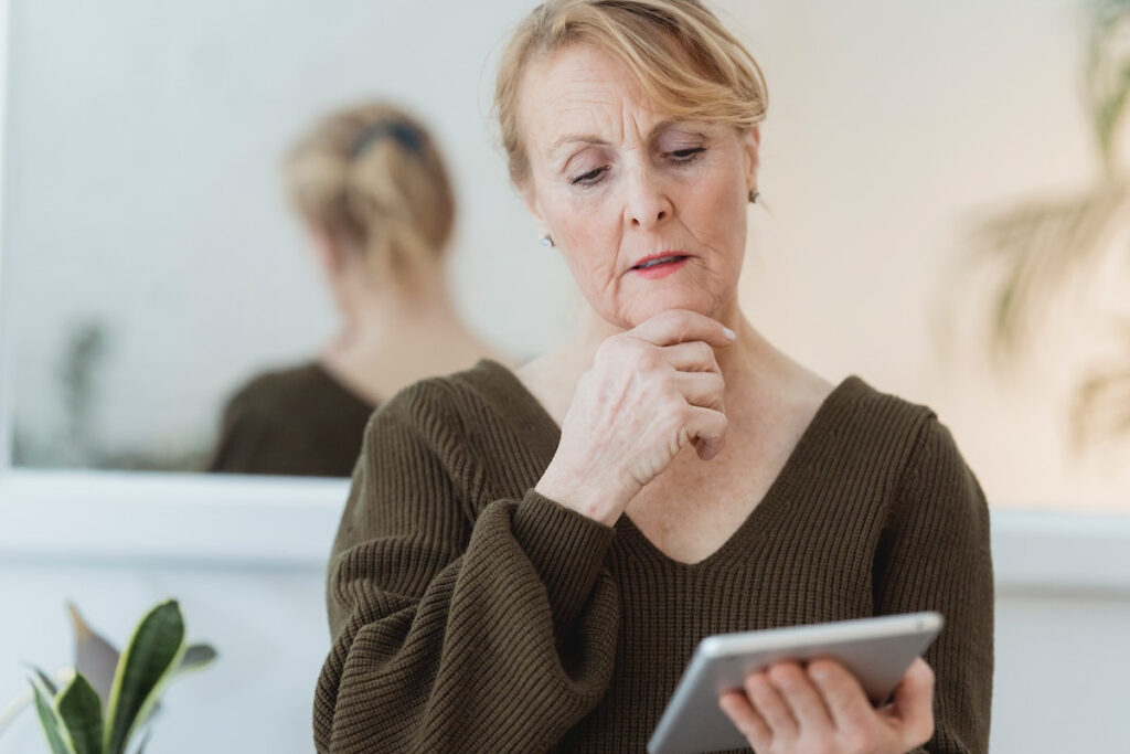 Femme senior lisant un article sur les chutes de la vie quotidienne sur son iPad